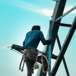 A construction worker securing a steel framework, helping to answer the question: do I need a structural engineer for my extension?