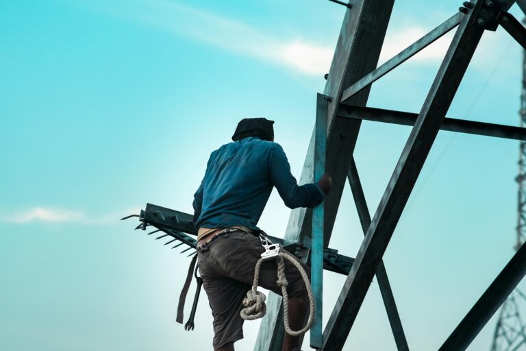 A construction worker securing a steel framework, helping to answer the question: do I need a structural engineer for my extension?