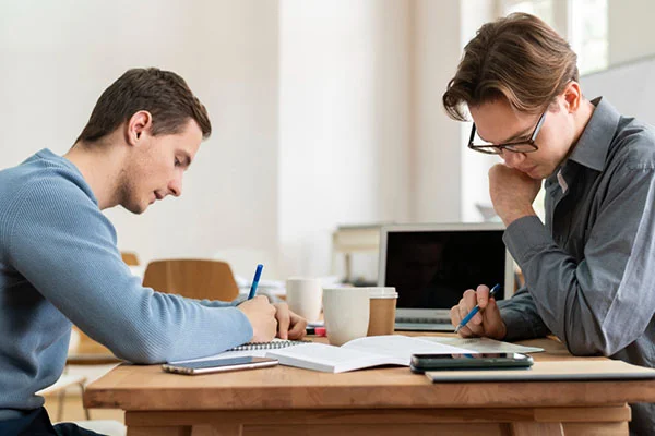 A professional team analyzing blueprints and data on a tablet, illustrating the complex planning topics covered in strategic management assignment help.