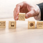 Man Arranging Wooden Cubes with Contact Symbols