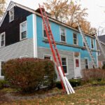 Vinyl siding being installed on a saltbox colonial house