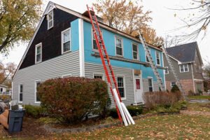 Vinyl siding being installed on a saltbox colonial house