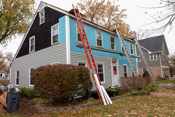 Vinyl siding being installed on a saltbox colonial house