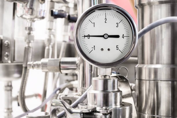 Hydraulic fluid pressure indicator. White dial. Abstract industrial background.