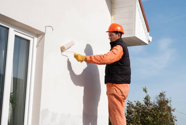 construction worker is painting a wall with a roller