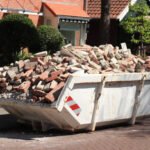 Garbage Dumpster filled wth old bricks near a construction site